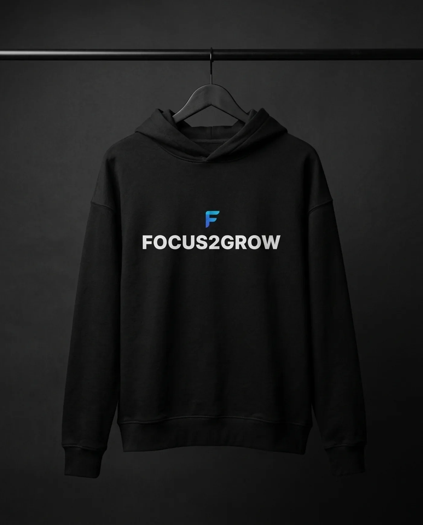 Фирменное худи Focus2Grow с логотипом F и надписью бренда, снятое на вешалке